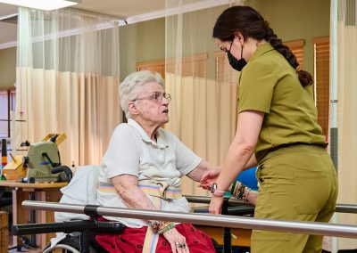 An elderly woman doing physical therapy with a therapist